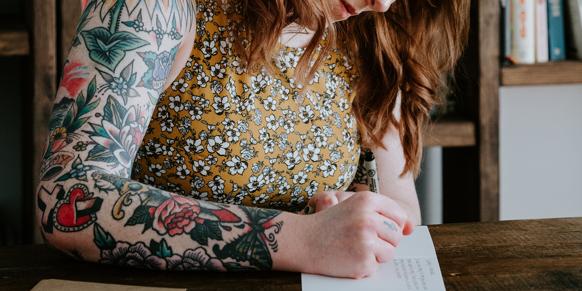 woman writing on a postcard