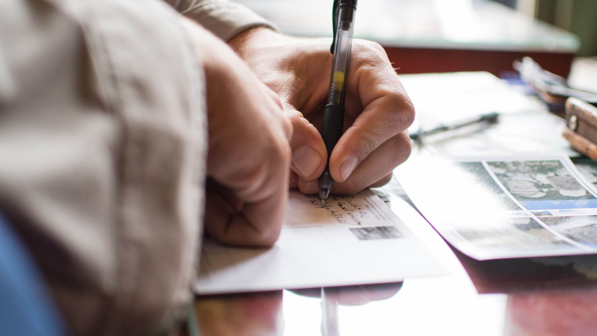 Hand writing postcard on desk